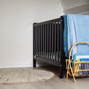 a convertible crib in a corner of the babies room